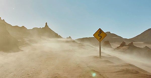 Desert road with dust cloud