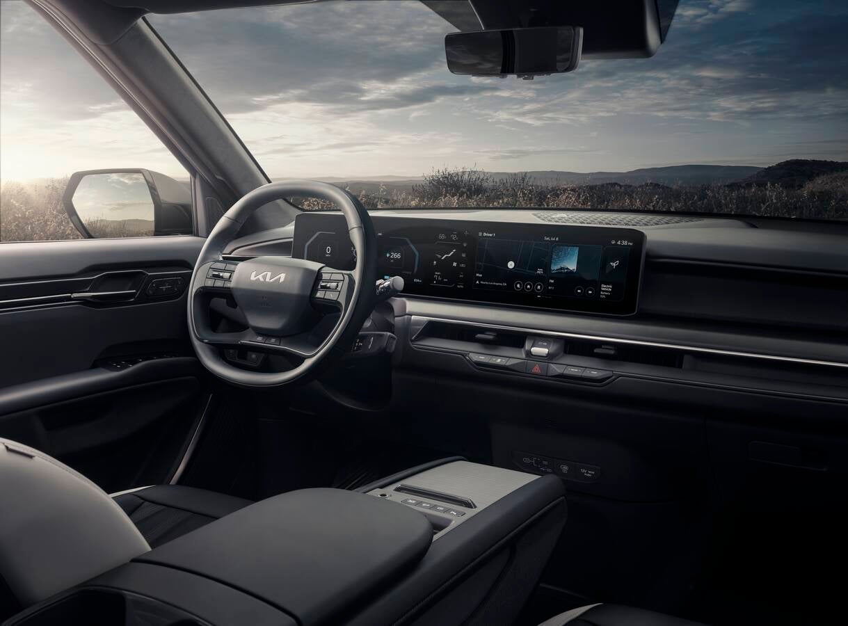 Close-up of a Kia dashboard showing the widescreen infotainment system running Apple CarPlay with colorful app icons displayed.