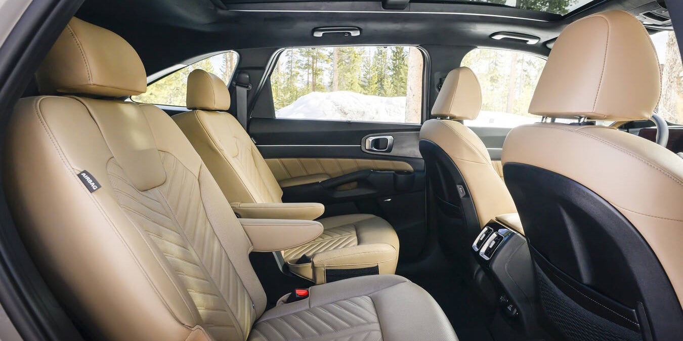 The tan seats inside the 2026 Kia Sorento in Peoria are seen from the back passenger window looking across the backseats.