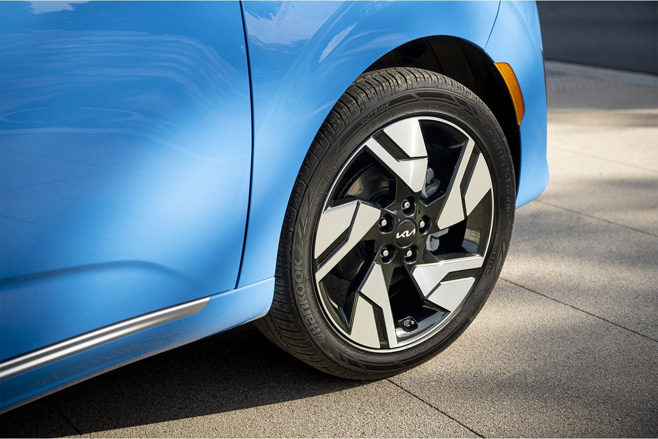 A closeup of the front passenger wheel of the new Kia Soul in Phoenix parked facing away from the viewer to the right on a tiled driveway.