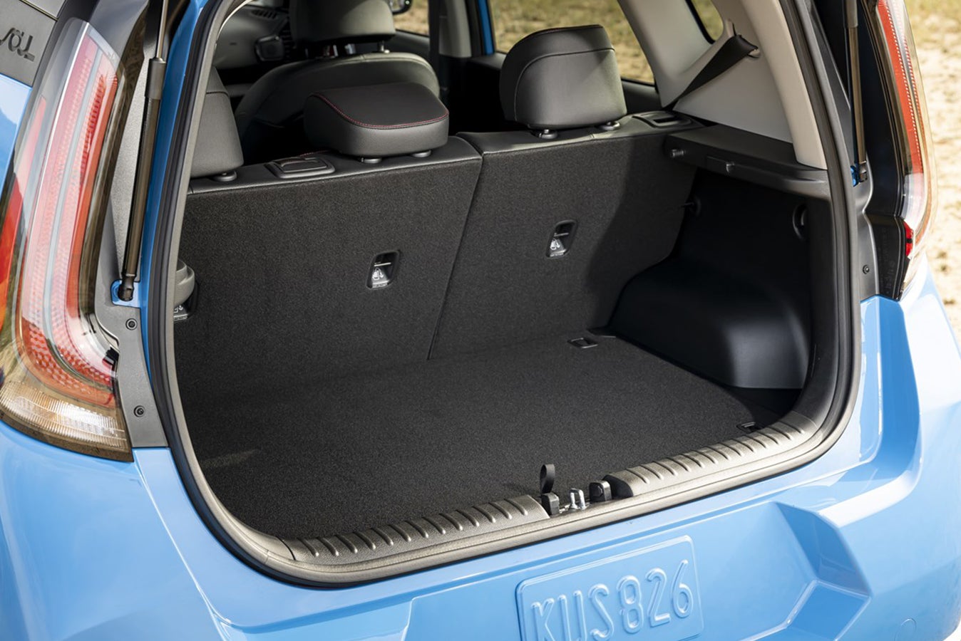 The large cargo hold of a blue 2026 Kia Soul in Surprise AZ is seen from behind the open rear door.