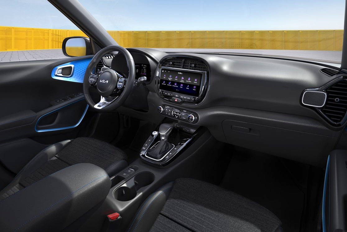 The black interior of a new blue Kia Soul in Phoenix is seen from the perspective of a person in the passenger's seat.