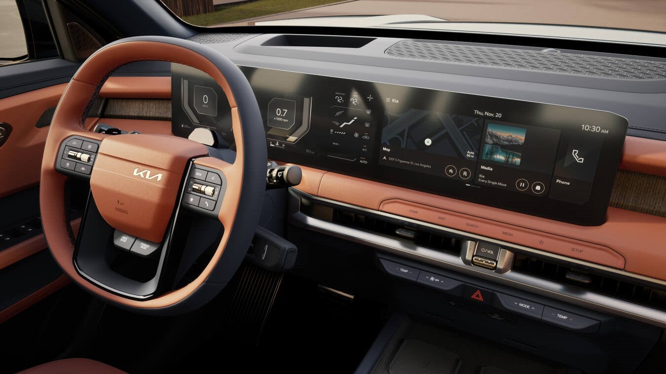 The burnt orange steering wheel and front dash is seen up close from the perspective of the front passenger of the 2026 Kia SUV in Peoria.