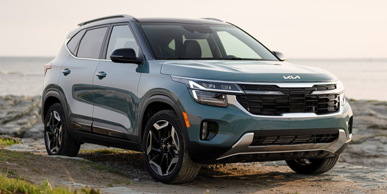 Teal Kia Seltos SUV on a rocky surface.